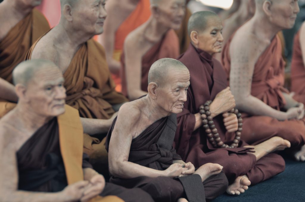 monjes sentados en el piso mientras rezan