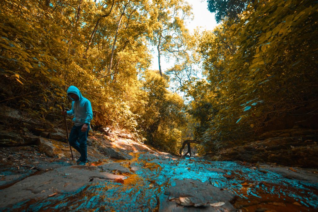 Persona practicando trekking a lado de un río