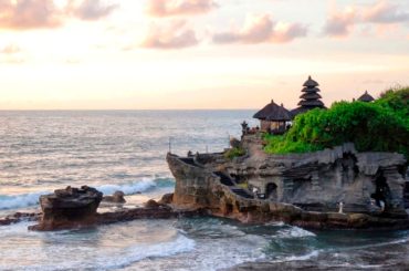 El templo de Tanah Lot sobre una roca frente al mar al atardecer, Bali