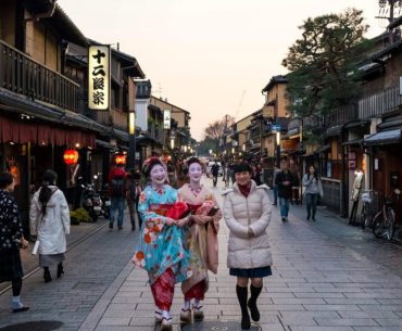 Calle tradicional del barrio de Gion en Kioto con mujeres en kimono al atardecer